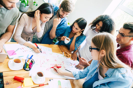 Team discussing notes on a board, symbolizing collaboration and analysis in value stream assessments.