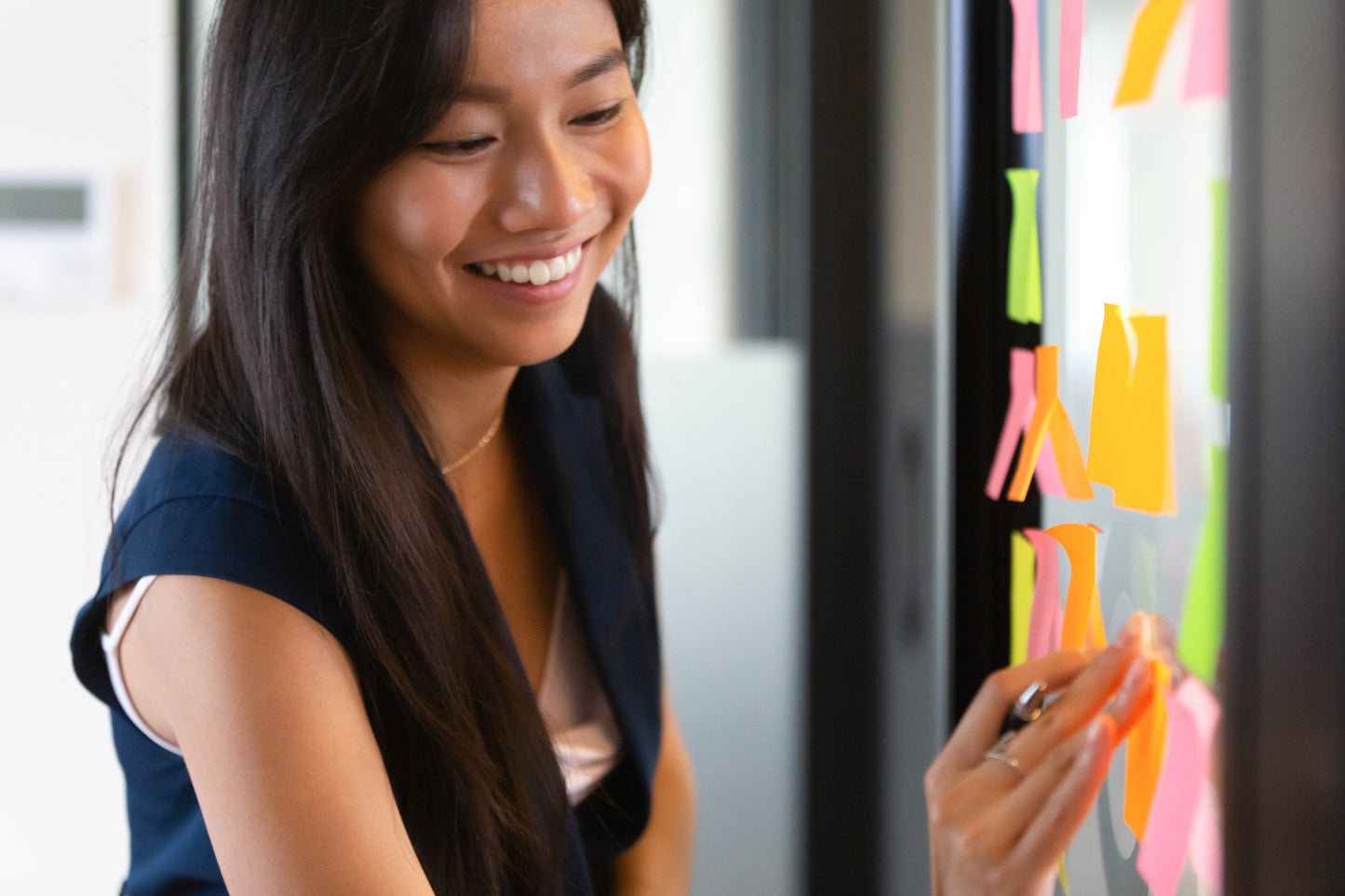 Facilitator organizing ideas with post-it notes, symbolizing collaborative and hands-on training methods.