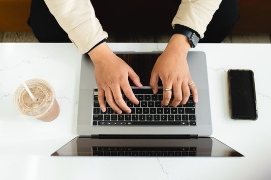 Flat lay of hands typing on a keyboard, symbolizing online learning and self-paced education.