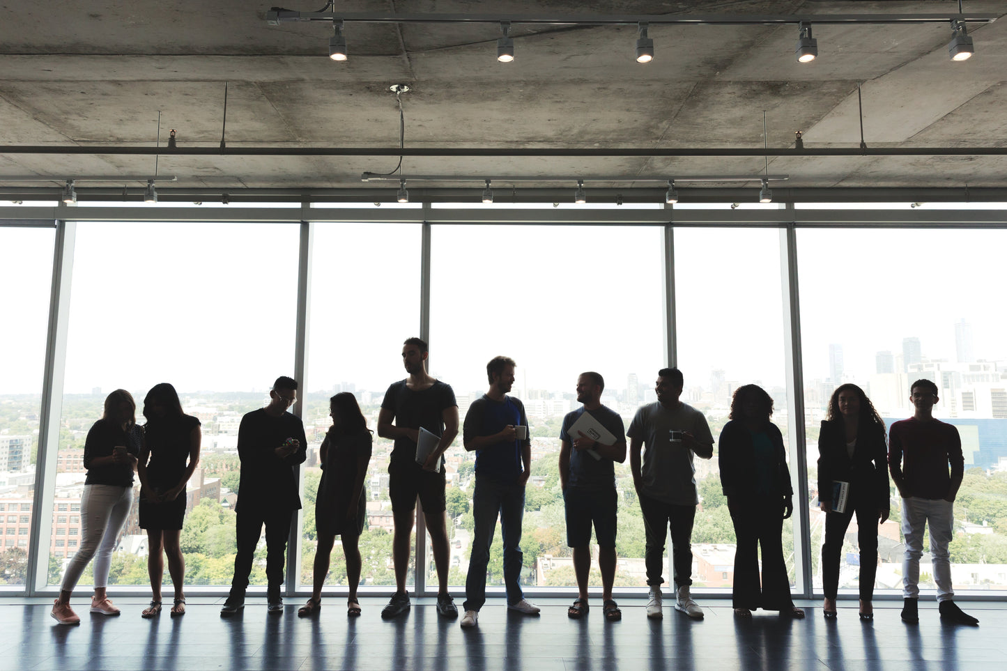 Large group of professionals standing in an office, symbolizing collaboration and leadership in driving organizational change.
