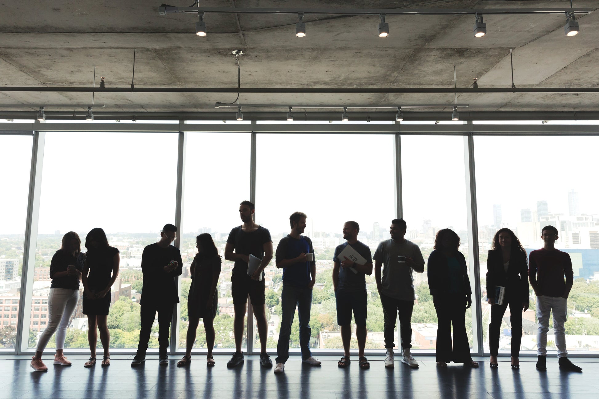 Large group of professionals standing in an office, symbolizing collaboration and leadership in driving organizational change.